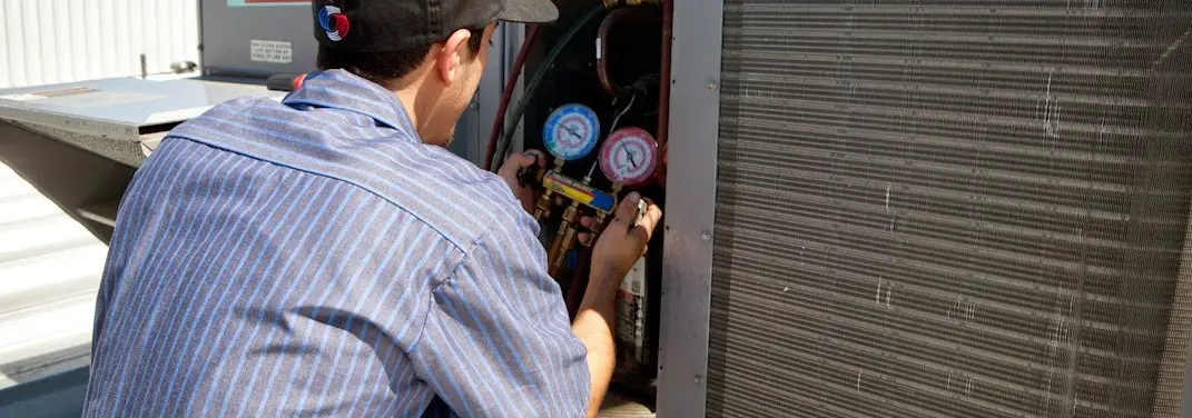 HVAC technician servicing a condenser unit in Savannah